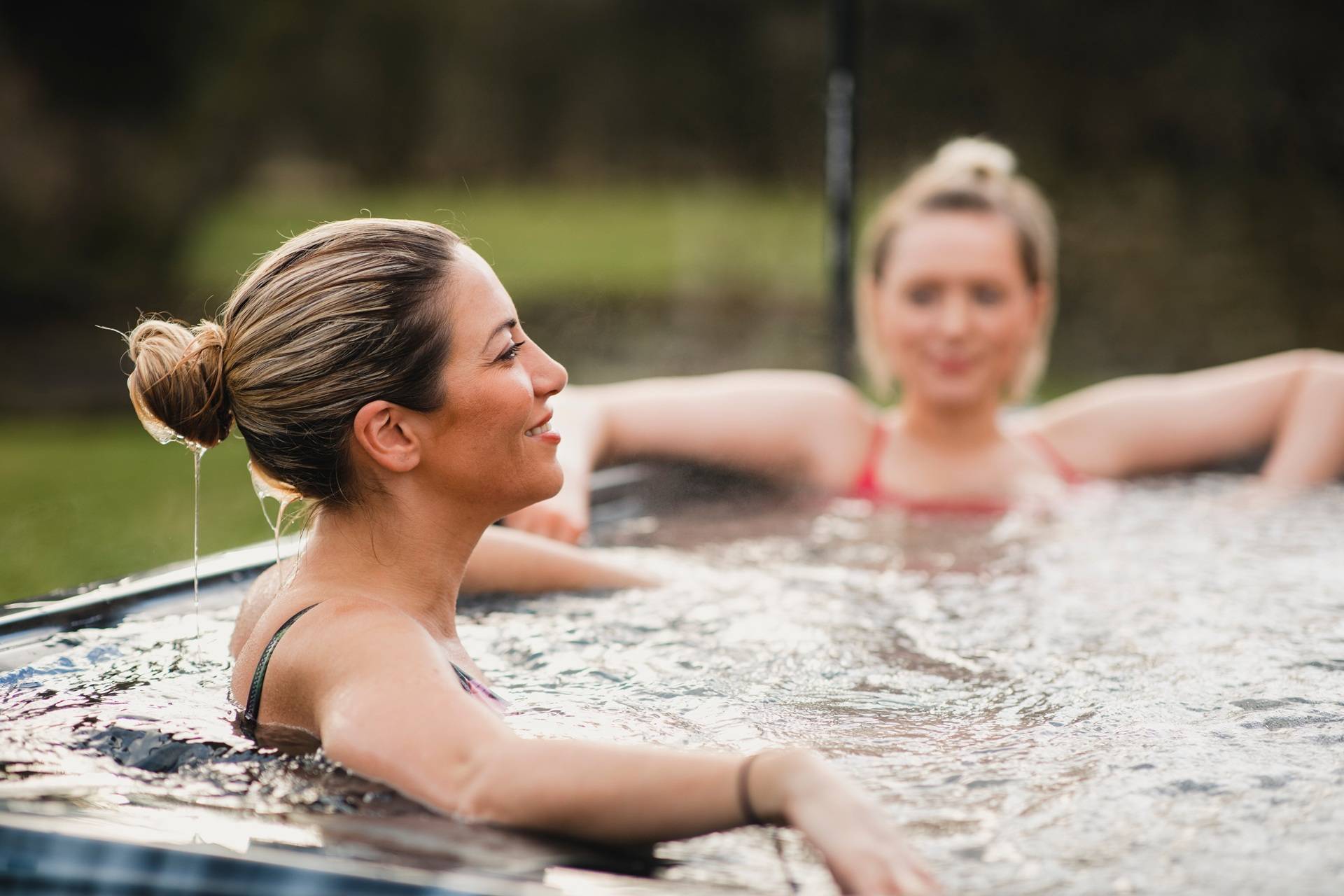 Zwei Frauen entspannen im warmen Außenbad | Hot Tubs